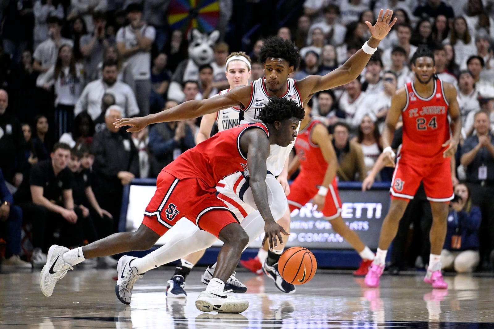 St. John's guard Kadary Richmond dribbles around UConn center Tarris Reed Jr., back, in the second half of an NCAA college basketball game, Friday, Feb. 7, 2025, in Storrs, Conn. (AP Photo/Jessica Hill)