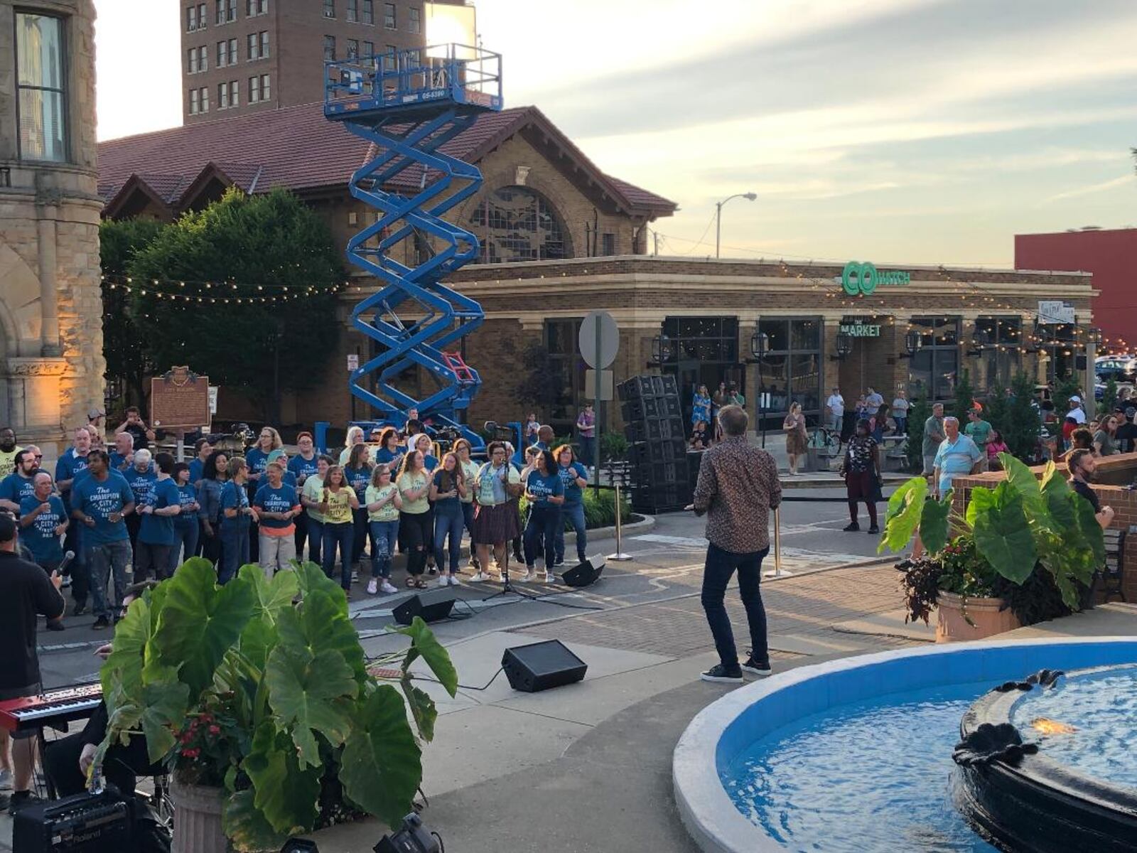 David Brown of Harmony Project conducts a chorus of about 90 people from Springfield and other areas as part of the filming of a television pilot in front of the Heritage Center in downtown Springfield on Saturday evening.