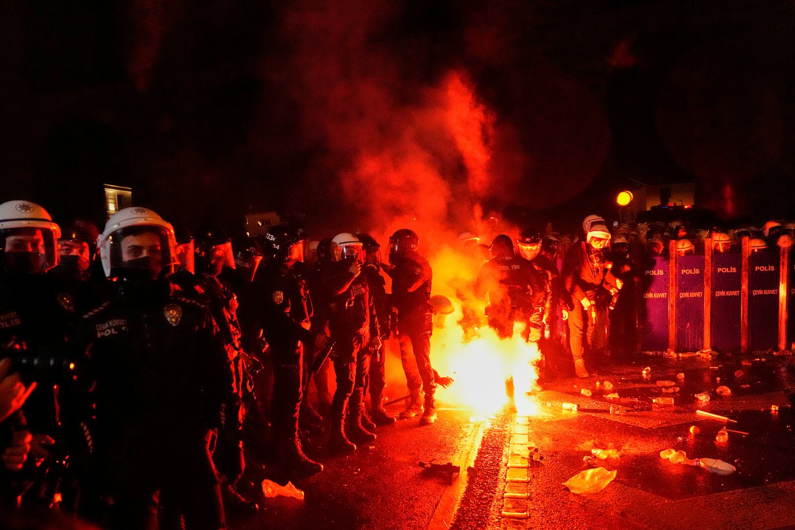 Protesters throw a flare to anti riot police men during clashes in a rally against the arrest of Istanbul's Mayor Ekrem Imamoglu, in Istanbul, Turkey, Friday, March 21, 2025. (AP Photo/Khalil Hamra)