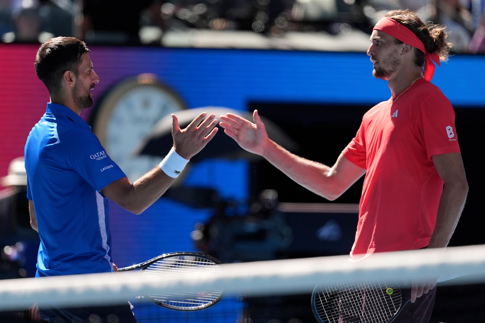 Alexander Zverev of Germany shakes hands with Novak Djokovic of Serbia after Djokovic retired from their semifinal match at the Australian Open tennis championship in Melbourne, Australia, Friday, Jan. 24, 2025. (AP Photo/Ng Han Guan)