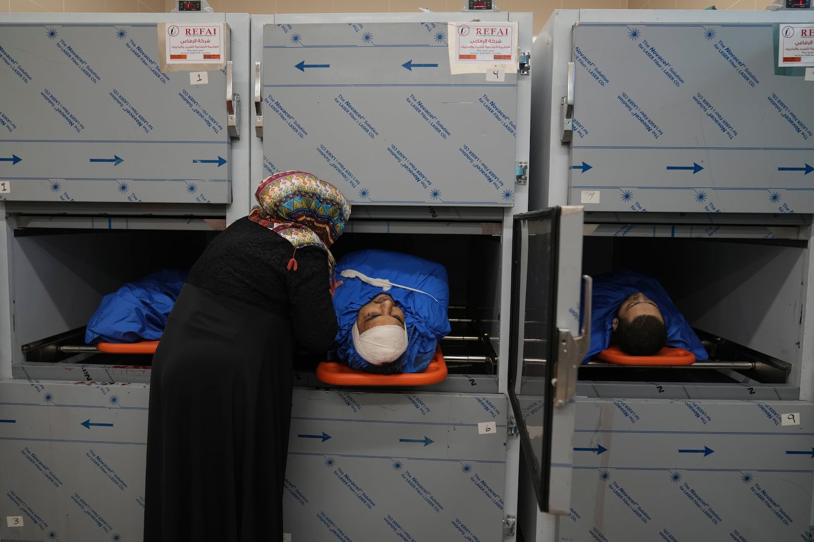 Relatives of Palestinian Husam Mallah, 28, center, Abdulaziz Abu al-Samen, 21, right and Ahmad Fahmawi, 19, in the morgue of a local hospital, as the Palestinian Health Ministry said two Palestinians were killed in an Israeli strike and a third by Israeli gunfire, in the West Bank city of Tulkarem Thursday, Oct. 31, 2024. (AP Photo/Nasser Nasser)