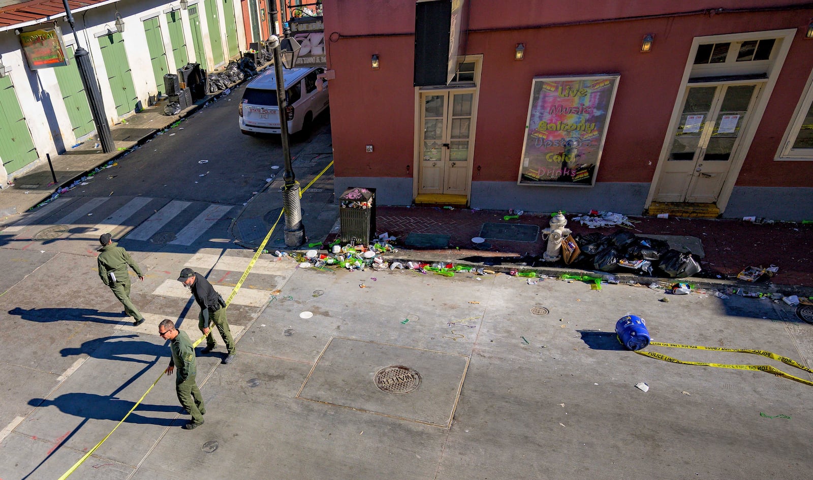 Members of the FBI and bomb squad detonated a suspicious package from the blue cooler, bottom right, damaging a doorway according to an eyewitness at Bourbon Street near Toulouse Street during the investigation of truck crashing into pedestrians on Bourbon Street in the French Quarter in New Orleans, Wednesday, Jan. 1, 2025. (AP Photo/Matthew Hinton)