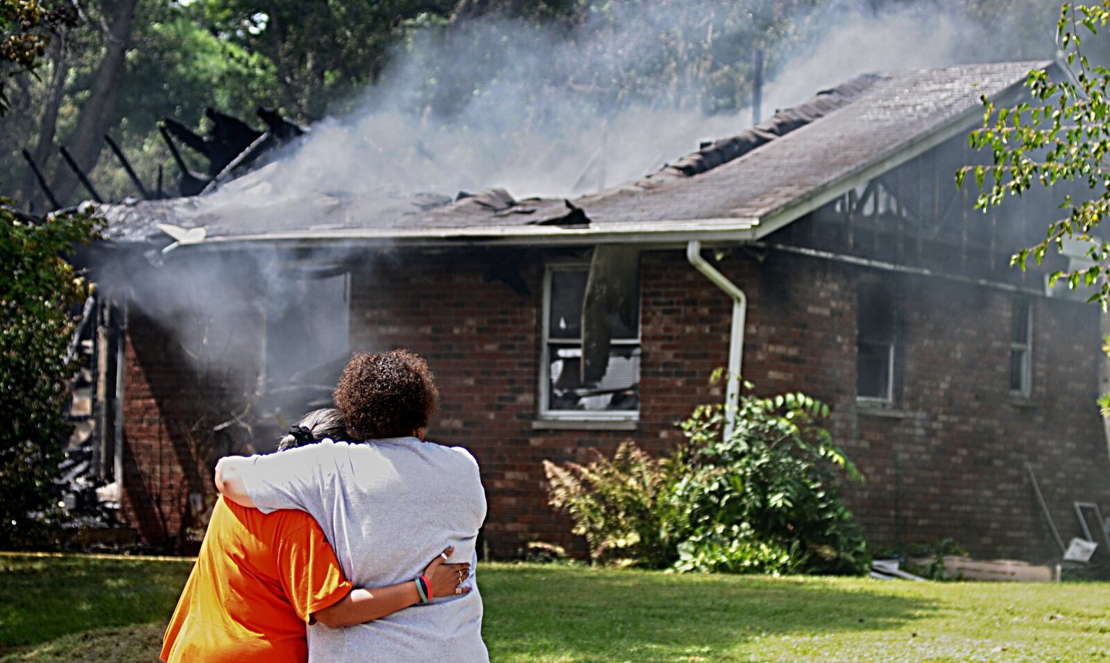 Firefighters console a family member during a fatal fire incident in Yellow Springs on Friday, Aug. 24, 2018. MARSHALL GORBY / STAFF