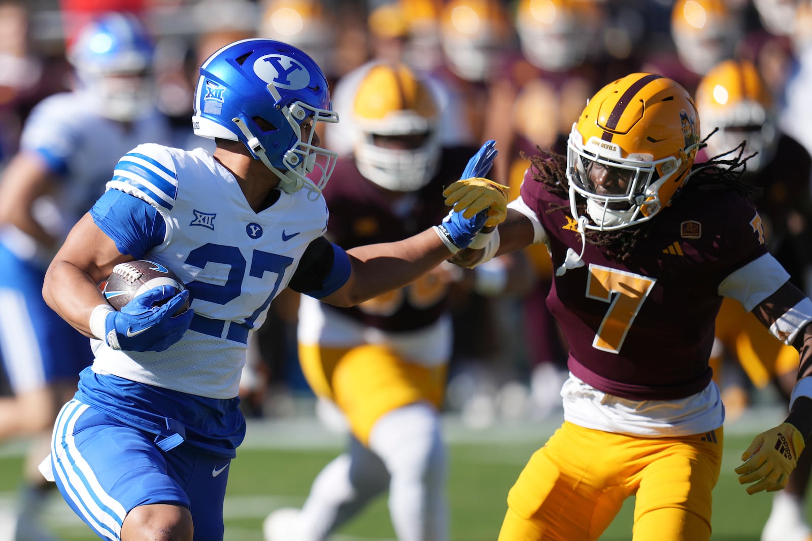 BYU running back LJ Martin (27) tries to get past Arizona State defensive back Shamari Simmons (7) during the first half of an NCAA college football game Saturday, Nov. 23, 2024, in Tempe, Ariz. (AP Photo/Ross D. Franklin)