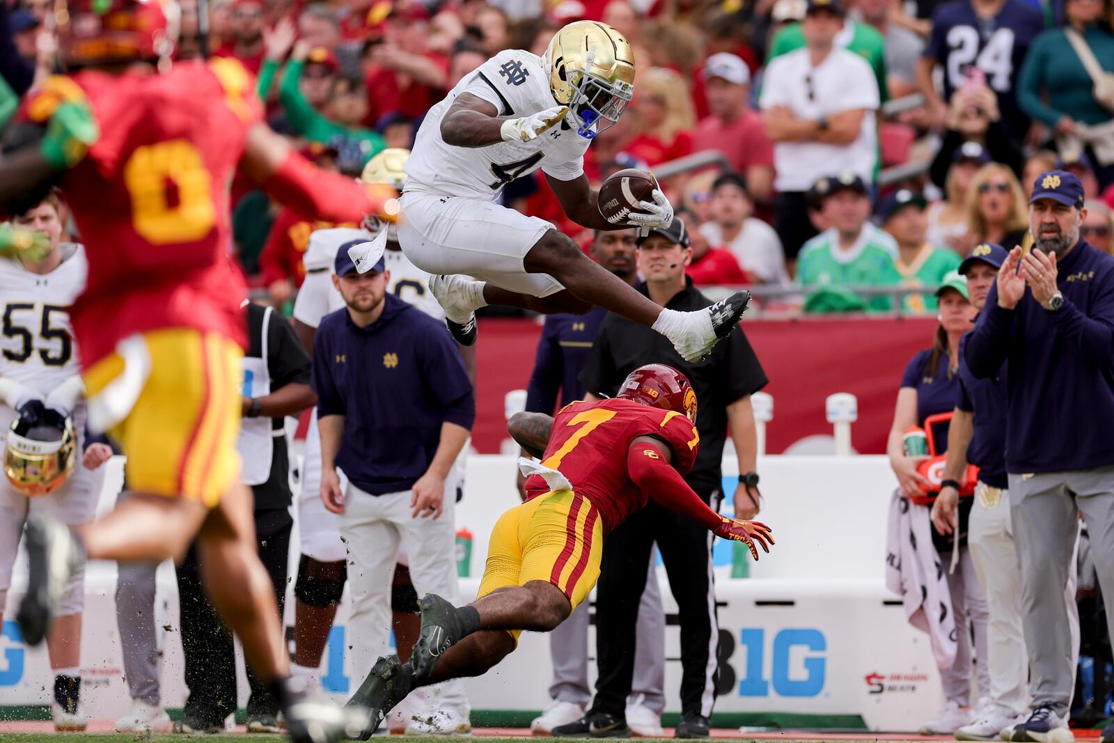 Notre Dame running back Jeremiyah Love, top, hurdles Southern California safety Kamari Ramsey during the first half of an NCAA football game, Saturday, Nov. 30, 2024, in Los Angeles. (AP Photo/Ryan Sun)