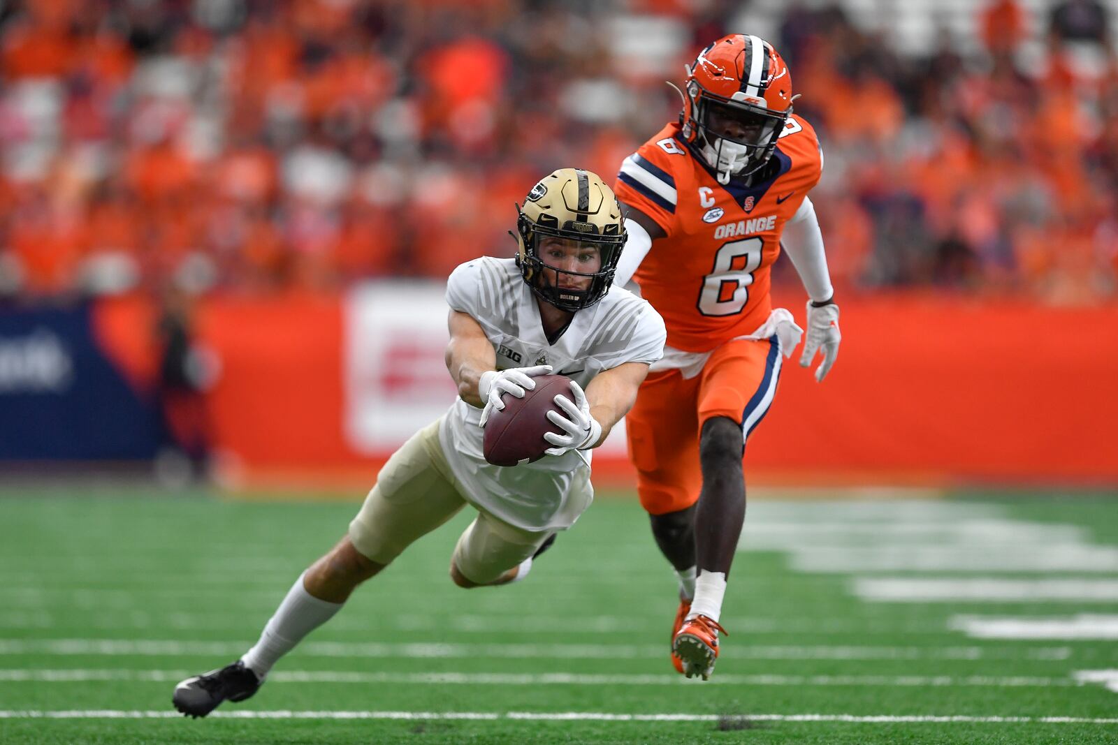 FILE - Purdue wide receiver Charlie Jones, left, reaches for a pass while defended by Syracuse defensive back Garrett Williams during the first half of an NCAA college football game in Syracuse, N.Y., Saturday, Sept. 17, 2022. Jones was selected top first-year transfer in the Associated Press Big Ten Midseason Awards, Tuesday, Oct. 11, 2022. AP Photo/Adrian Kraus)