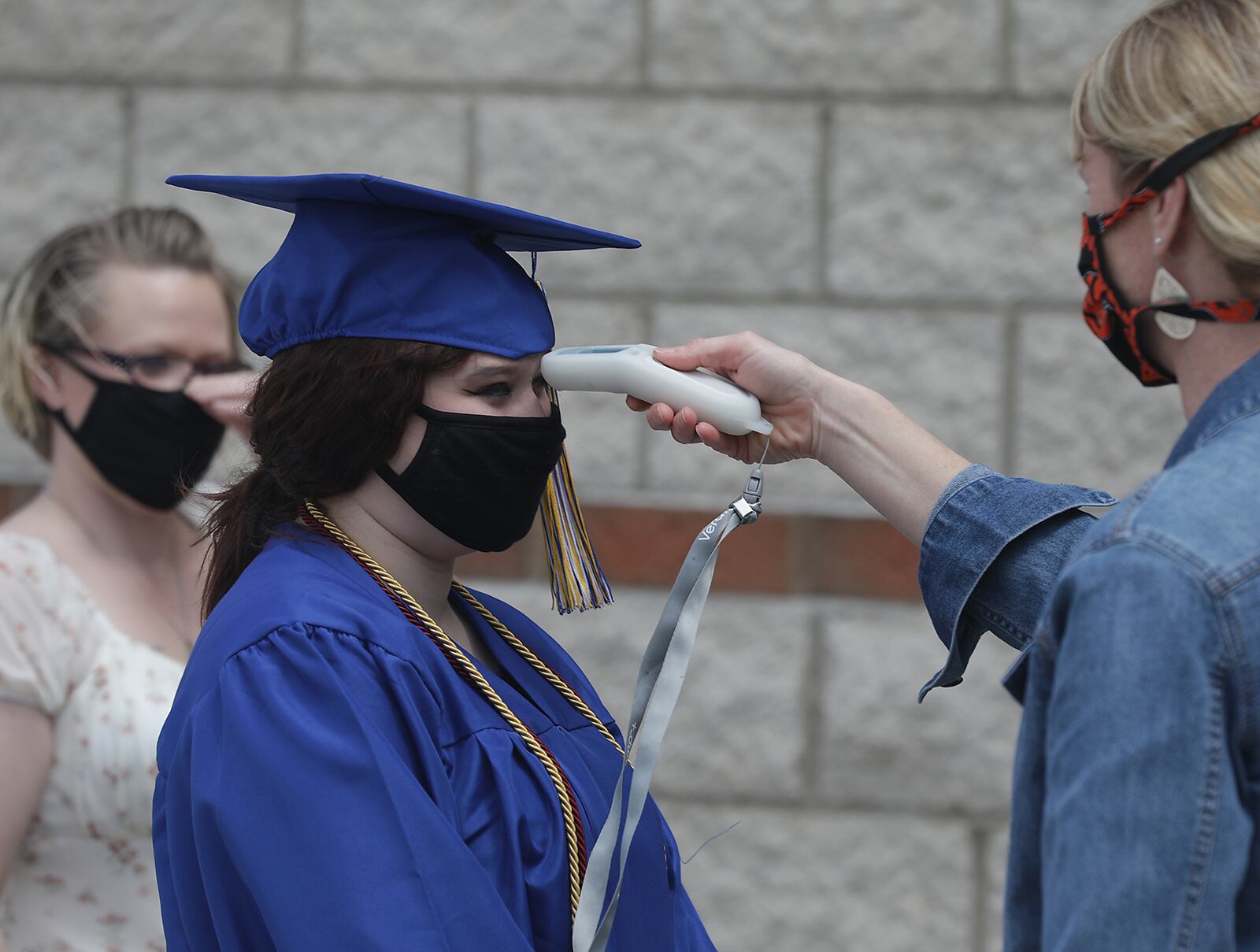 Students and their guests have their temperature taken before entering Springfield High School for their individual graduation ceremony on May 14. BILL LACKEY/STAFF