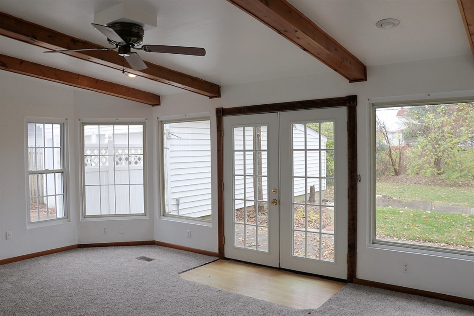 The French patio doors open to a concrete patio, part of which is covered. 