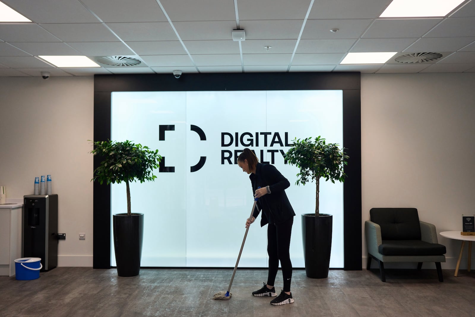 A cleaner mops the floor in the reception hall of an empty data center building, in Dublin, Ireland, Thursday, Oct. 17, 2024. (AP Photo/Bram Janssen)