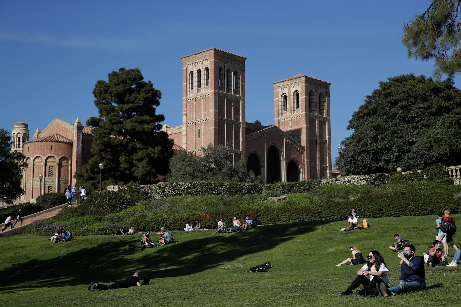 FILE - Students sit on the lawn near Royce Hall at the University of California, Los Angeles, in the Westwood section of Los Angeles on April 25, 2019. (AP Photo/Jae C. Hong, File)