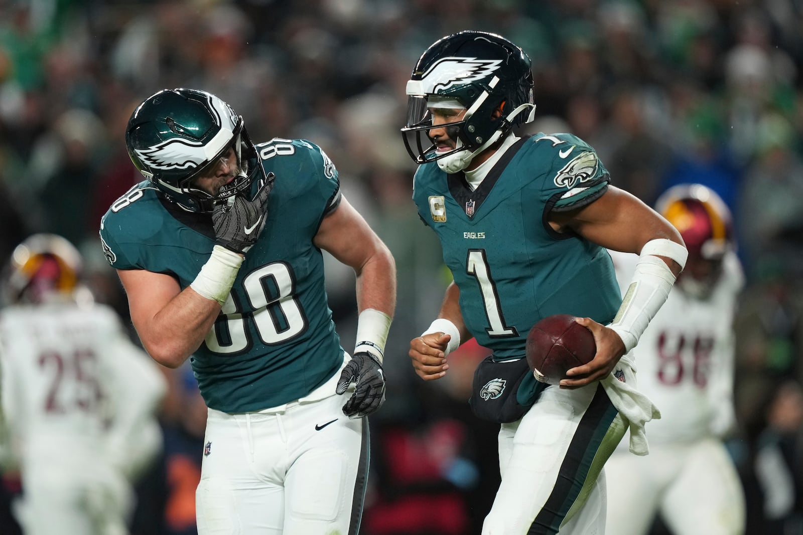 Philadelphia Eagles quarterback Jalen Hurts (1) is congratulated by teammate Dallas Goedert (88) after scoring during the second half of an NFL football game against the Washington Commanders Thursday, Nov. 14, 2024, in Philadelphia. (AP Photo/Matt Slocum)