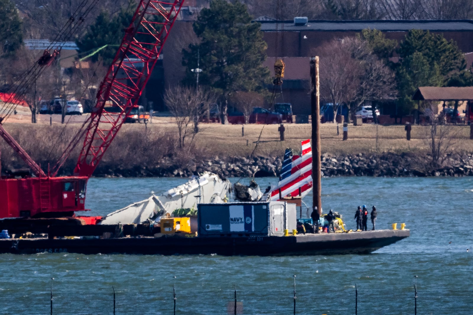 Parts of a plane are lifted from the water near the wreckage site in the Potomac River of a mid-air collision between an American Airlines jet and a Black Hawk helicopter, at Ronald Reagan Washington National Airport, Tuesday, Feb. 4, 2025, in Arlington, Va. (AP Photo/Ben Curtis)