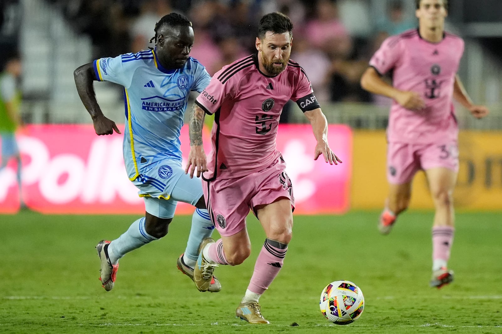 Atlanta United midfielder Tristan Muyumba (8) and Inter Miami forward Lionel Messi (10) go after the ball during the second half of of their MLS playoff opening round soccer match, Friday, Oct. 25, 2024, in Fort Lauderdale, Fla. (AP Photo/Rebecca Blackwell)