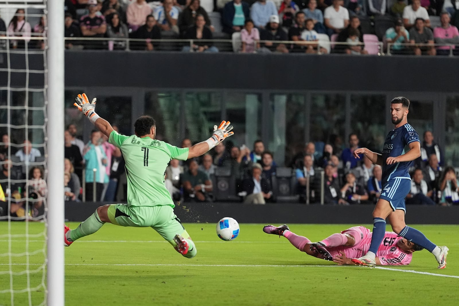 Inter Miami forward Luis Suarez, right, scores past Sporting Kansas City goalkeeper John Pulskamp (1) and defender Robert Voloder (4) during the first half of a CONCACAF Champions Cup soccer match, Tuesday, Feb. 25, 2025, in Fort Lauderdale, Fla. (AP Photo/Rebecca Blackwell)