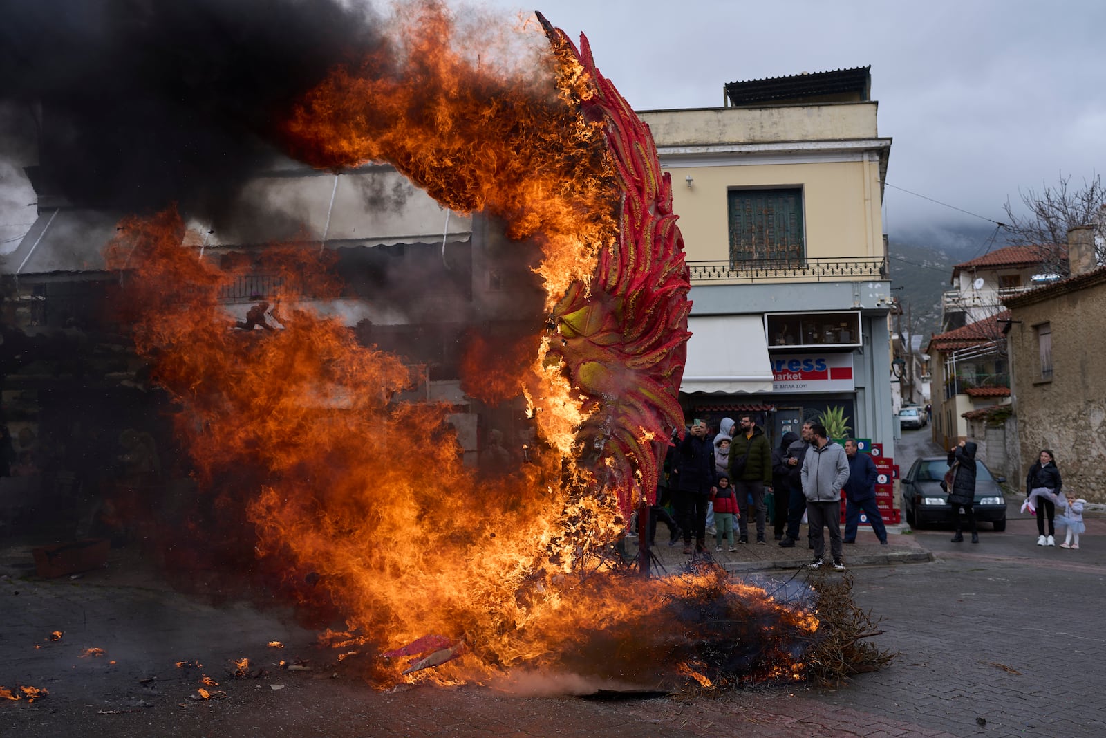 A carnival effigy is set alight as bystanders look on during carnival celebrations in Distomo, a village in central Greece, on Monday, March 3, 2025. (AP Photo/Petros Giannakouris)