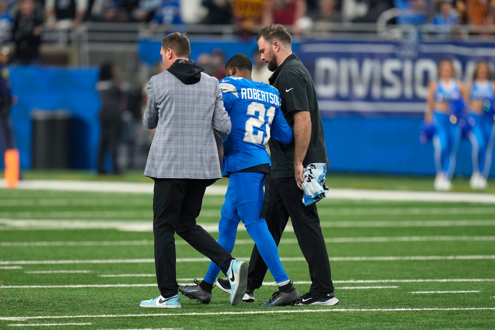 Detroit Lions cornerback Amik Robertson (21) is helped off the field against the Washington Commanders after being injured during the first half of an NFL football divisional playoff game, Saturday, Jan. 18, 2025, in Detroit. (AP Photo/Seth Wenig)