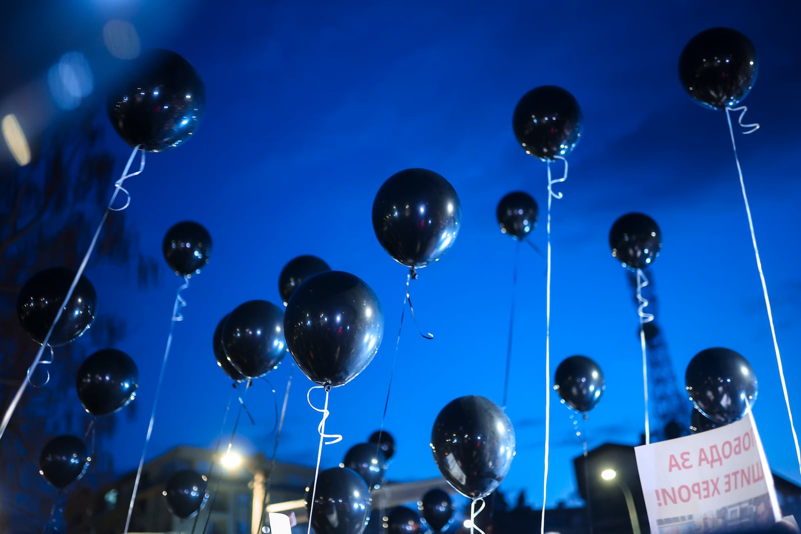 People taking part in a protest hold balloons in the town of Kocani, North Macedonia, Tuesday, March 18, 2025 following a massive fire in a nightclub early SUnday. (AP Photo/Armin Durgut)