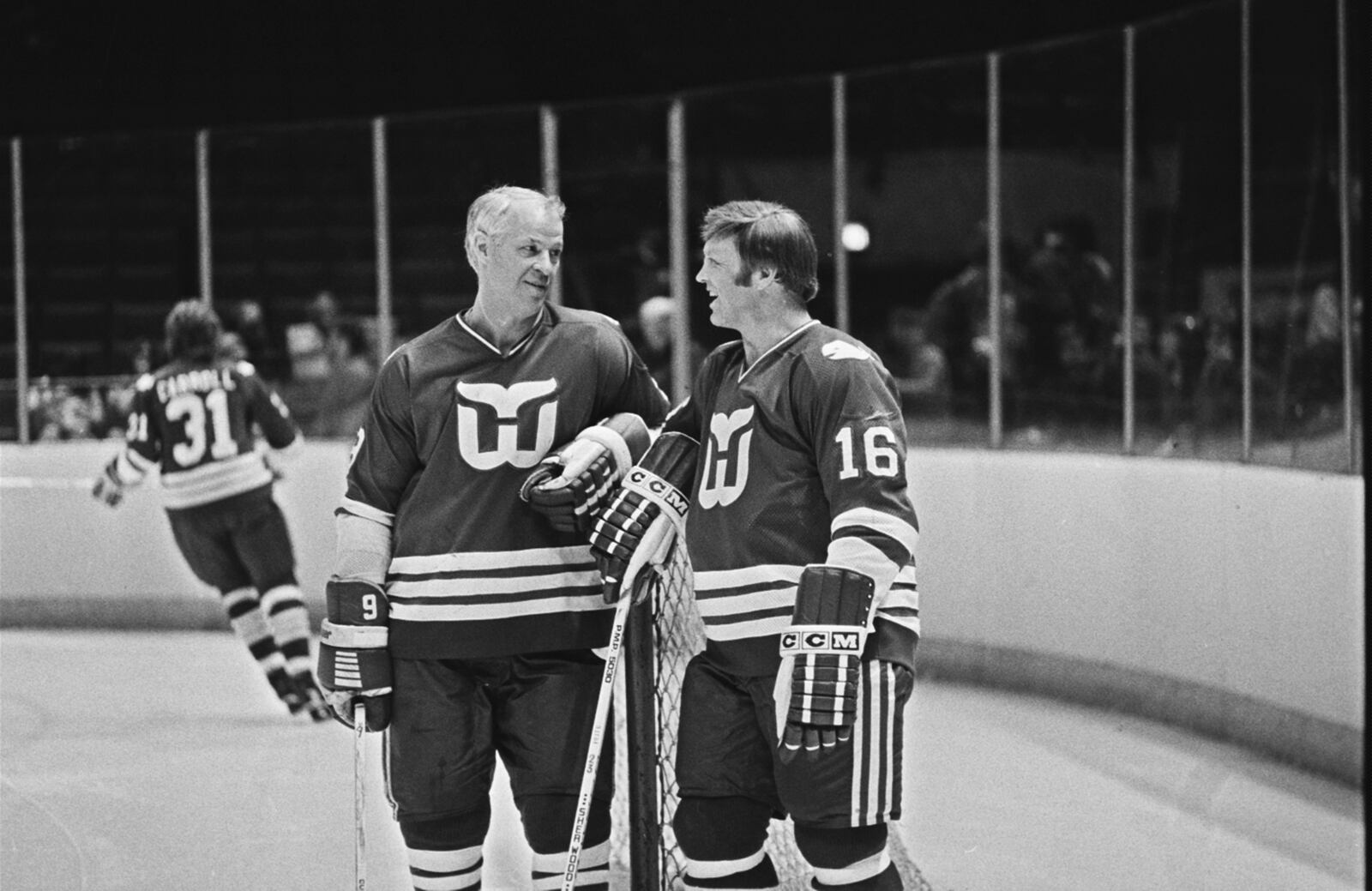 FILE - Hartford Whalers' star Gordie Howe, left, and Bobby Hull, right, have a chat as Hartford Whalers practice before their NHL game with the Washington Capitals, March 8, 1980. (AP Photo/William Smith, File)