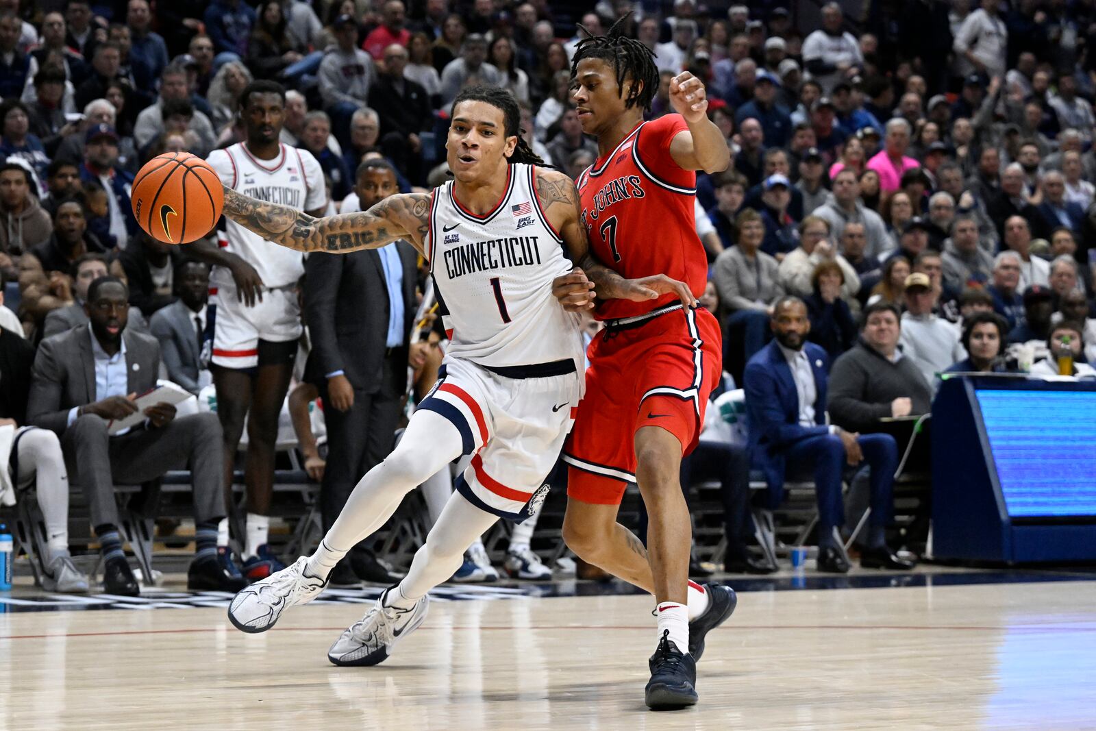 UConn guard Solo Ball (1) is guarded by St. John's guard Simeon Wilcher (7) in the second half of an NCAA college basketball game, Friday, Feb. 7, 2025, in Storrs, Conn. (AP Photo/Jessica Hill)