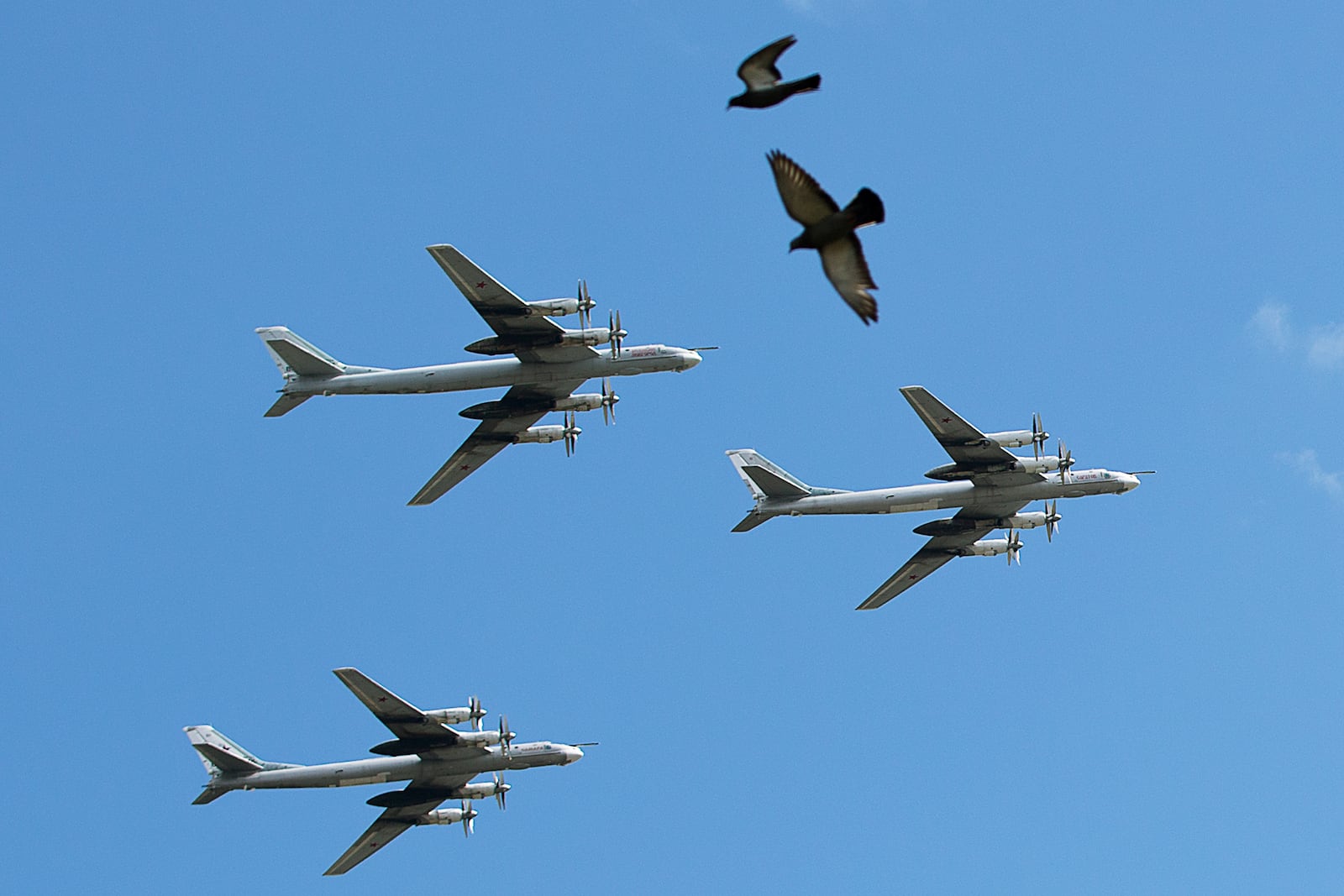 FILE - A trio of Tu-95 nuclear-capable strategic bombers of the Russian air force fly over Pushkin Square in Moscow, Russia, on May 3, 2014 during a rehearsal for the Victory Day military parade which will take place at Moscow's Red Square on May 9 to celebrate 69 years of the victory in WWII. (AP Photo/Pavel Golovkin, File)