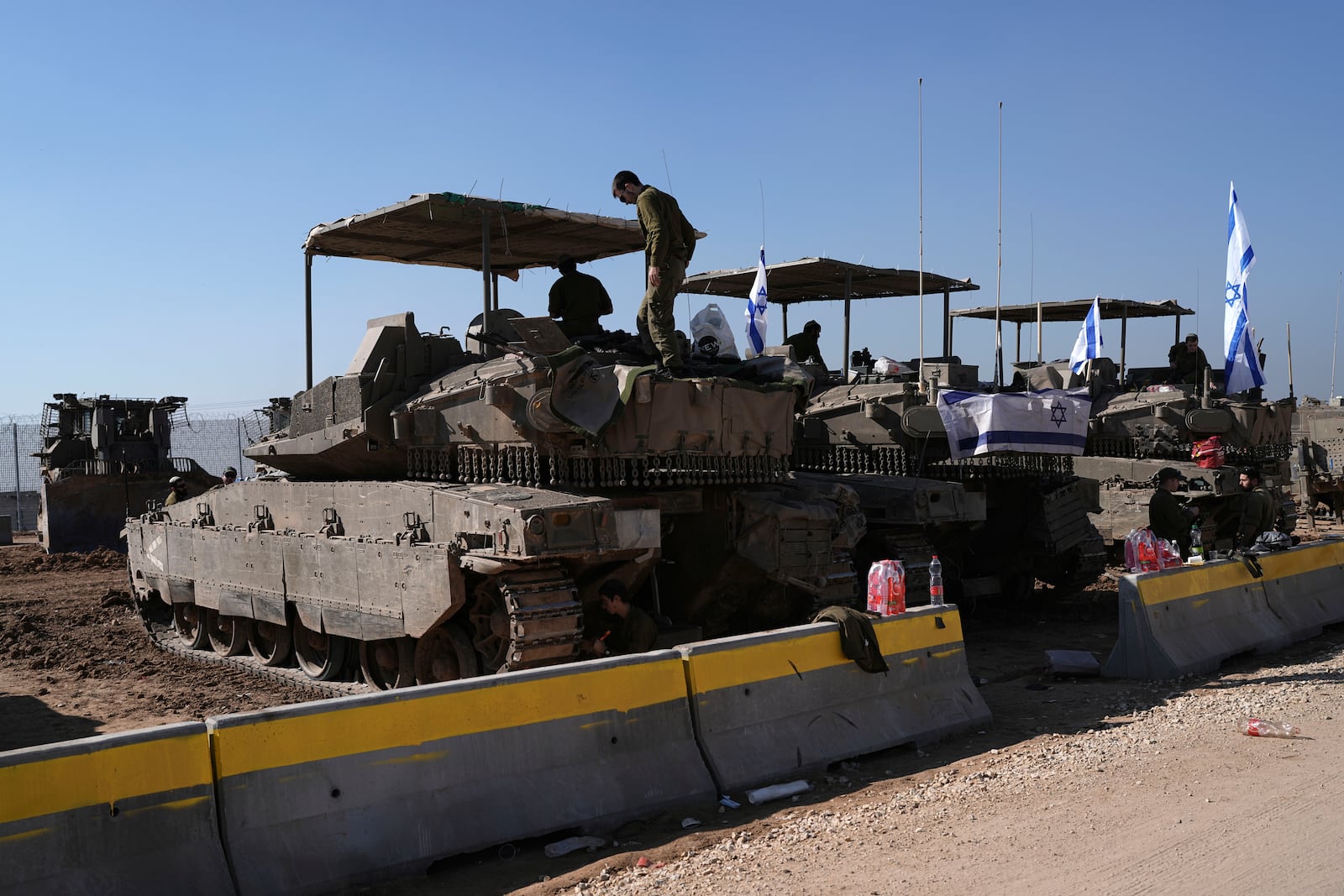 Israeli soldiers work in a staging area on the Israel-Gaza border after returning from the Gaza Strip, Saturday, Jan. 18, 2025, a day ahead of a ceasefire between Israel and Hamas. (AP Photo/Tsafrir Abayov)