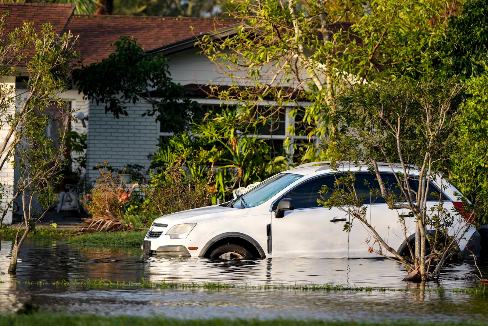 A car sits in high water in front of a home in the aftermath of hurricane Milton, Thursday, Oct. 10, 2024, in Tampa, Fla. (AP Photo/Mike Stewart)