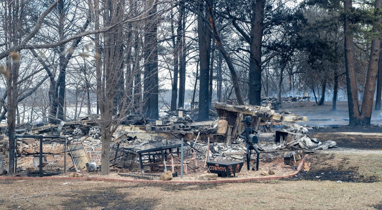 A row of RVs smolder Saturday, March 15, 2025, at the entrance to Fox Run at Lake Carl Blackwell near Stillwater, Okla. (Jason Elmquist/The News Press via AP)