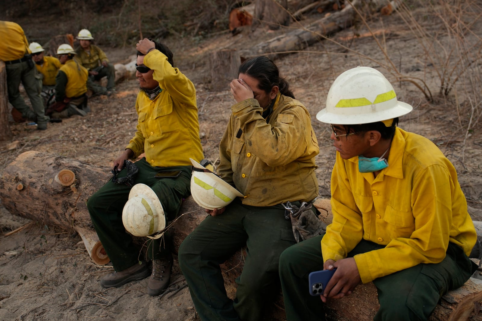 From left, Loren Tsosie, Deago Yanez, and Tyron Barber, of the Navajo Scouts firefighter crew, rest as they finish up working on the Eaton Fire, Friday, Jan. 17, 2025, in Pasadena, Calif. (AP Photo/John Locher)