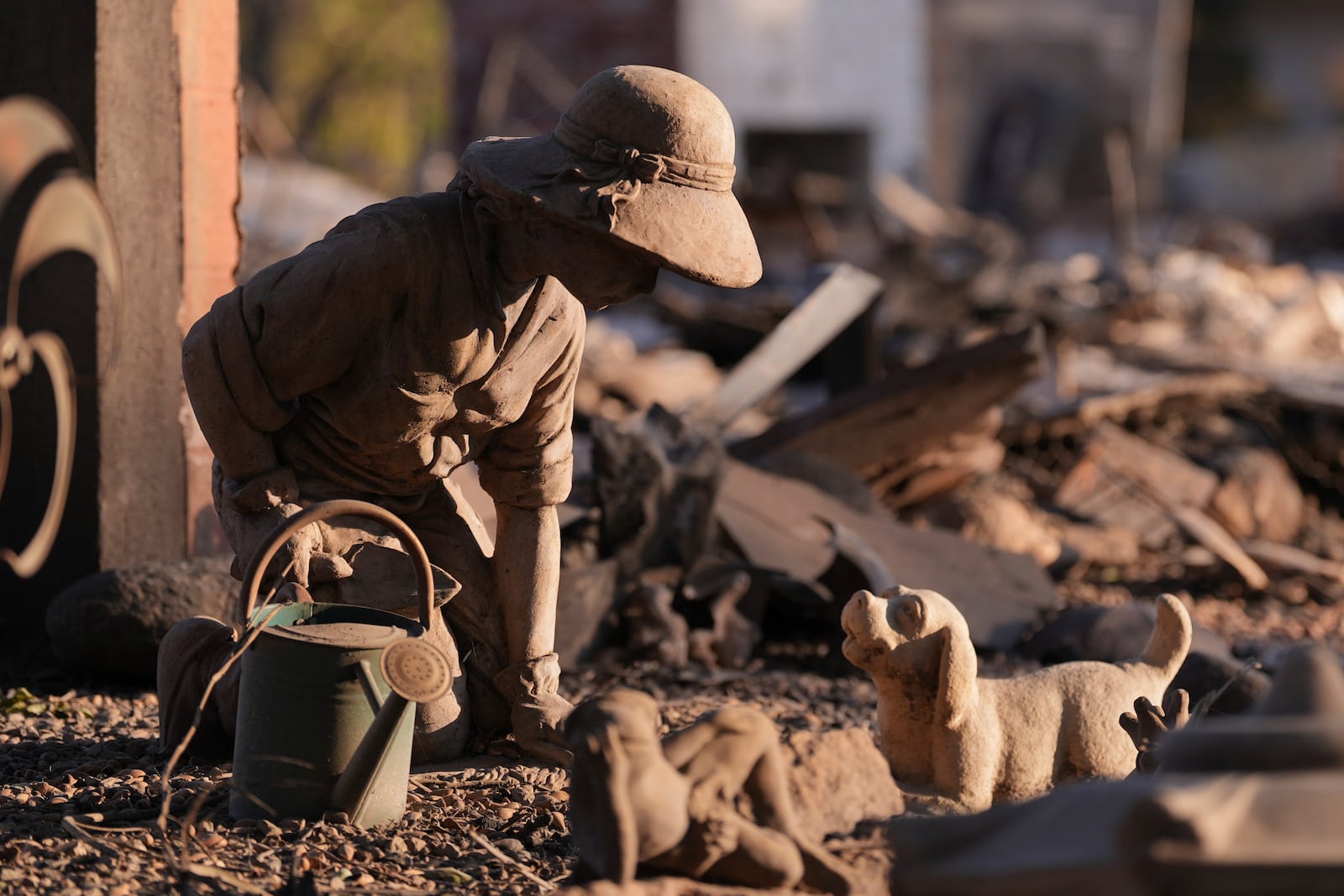 Statues stand amidst debris after the Eaton Fire destroyed a property in Altadena, Calif., Saturday, Jan. 11, 2025. (AP Photo/Mark J. Terrill)