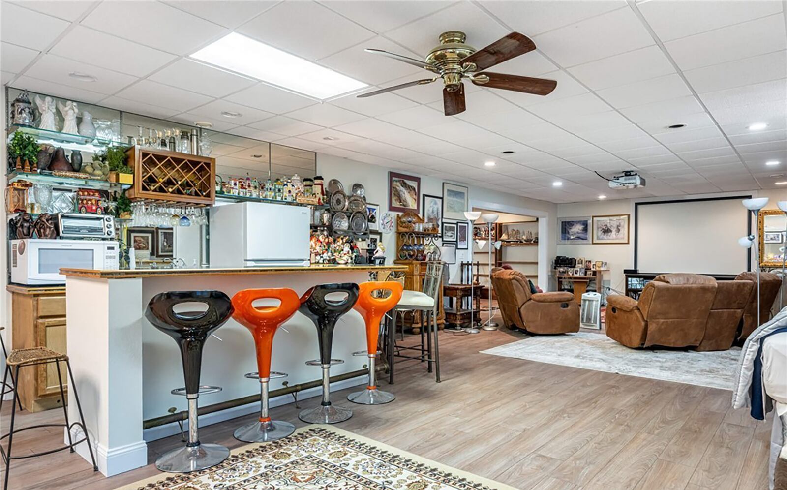 The finished walk out basement has multiple spaces including a theater room and game room and kitchenette. It walks out to the inground pool area.