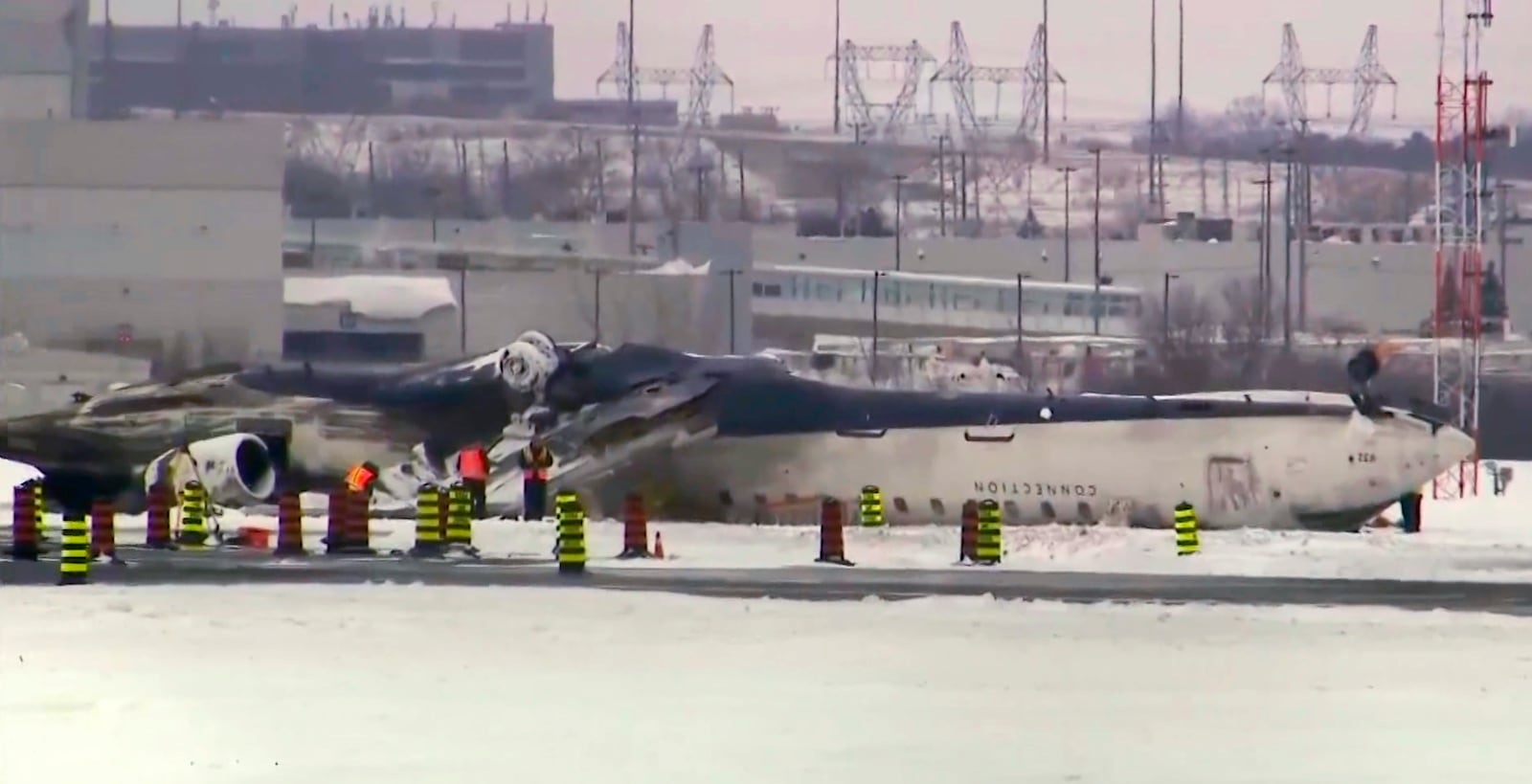 This image taken from video provided by CTV shows workers near the crashed passenger jet on a tarmac of the Toronto Pearson Airport on Wednesday, Feb.19, 2025. (CTV via AP)