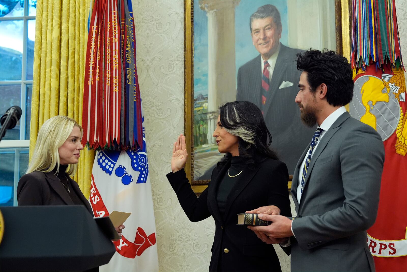 Attorney General Pam Bondi swears in Tulsi Gabbard ias the Director of National Intelligence in the Oval Office of the White House, Wednesday, Feb. 12, 2025, in Washington as her husband Abraham Williams holds the Bible. (Photo/Alex Brandon)