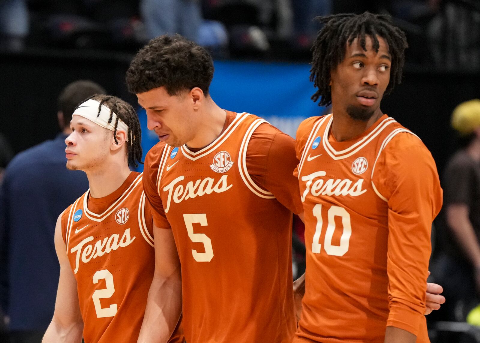 Texas' Kadin Shedrick (5) is consoled by teammates Chendall Weaver (2) and Nic Codie (10) following their loss to Xavier during a First Four college basketball game in the NCAA Tournament, Wednesday, March 19, 2025, in Dayton, Ohio. (AP Photo/Jeff Dean)