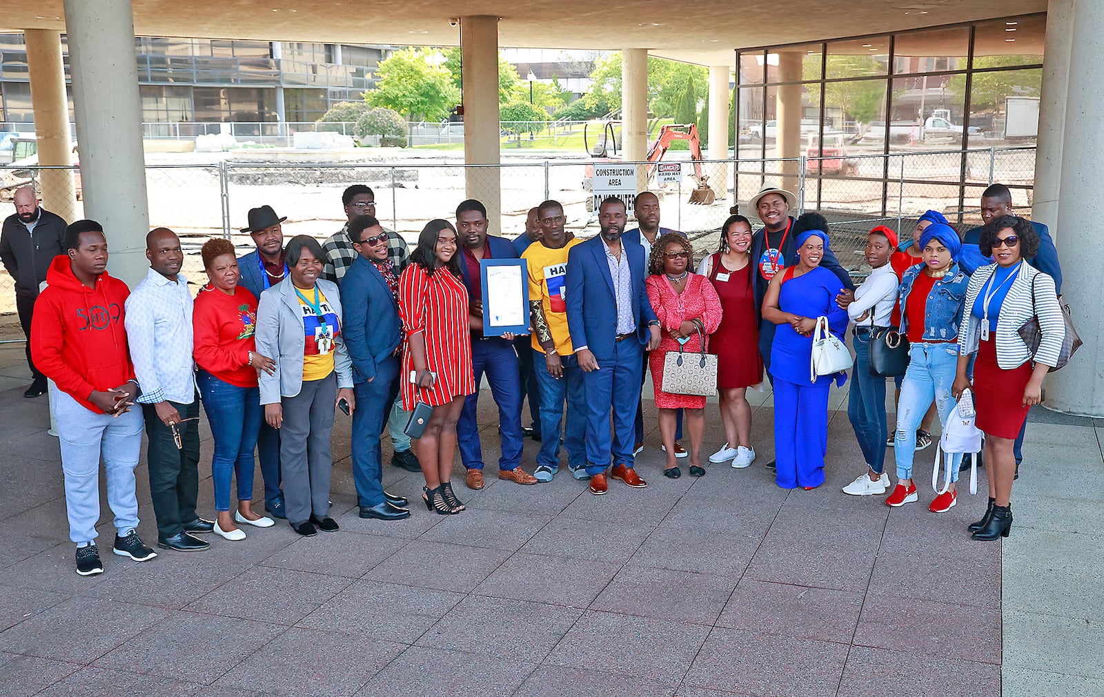 A group of Haitians pose for a picture during a ceremony Thursday, May 18, 2023 to raise the Haitian flag for the Flag Day holiday in Haiti. BILL LACKEY/STAFF