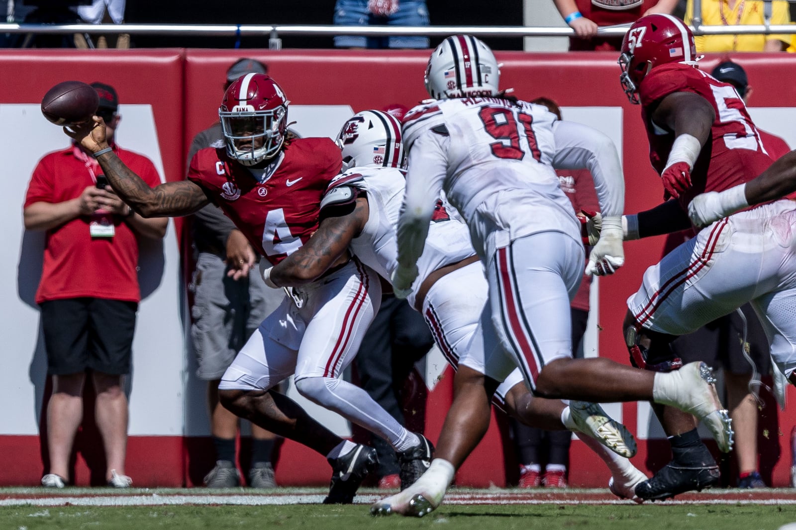 Alabama quarterback Jalen Milroe (4) throws the ball away in the end zone, under pressure from South Carolina defensive lineman Kyle Kennard (5), during the first half of an NCAA college football game, Saturday, Oct. 12, 2024, in Tuscaloosa, Ala. The play resulted in an intentional grounding call for a safety. (AP Photo/Vasha Hunt)