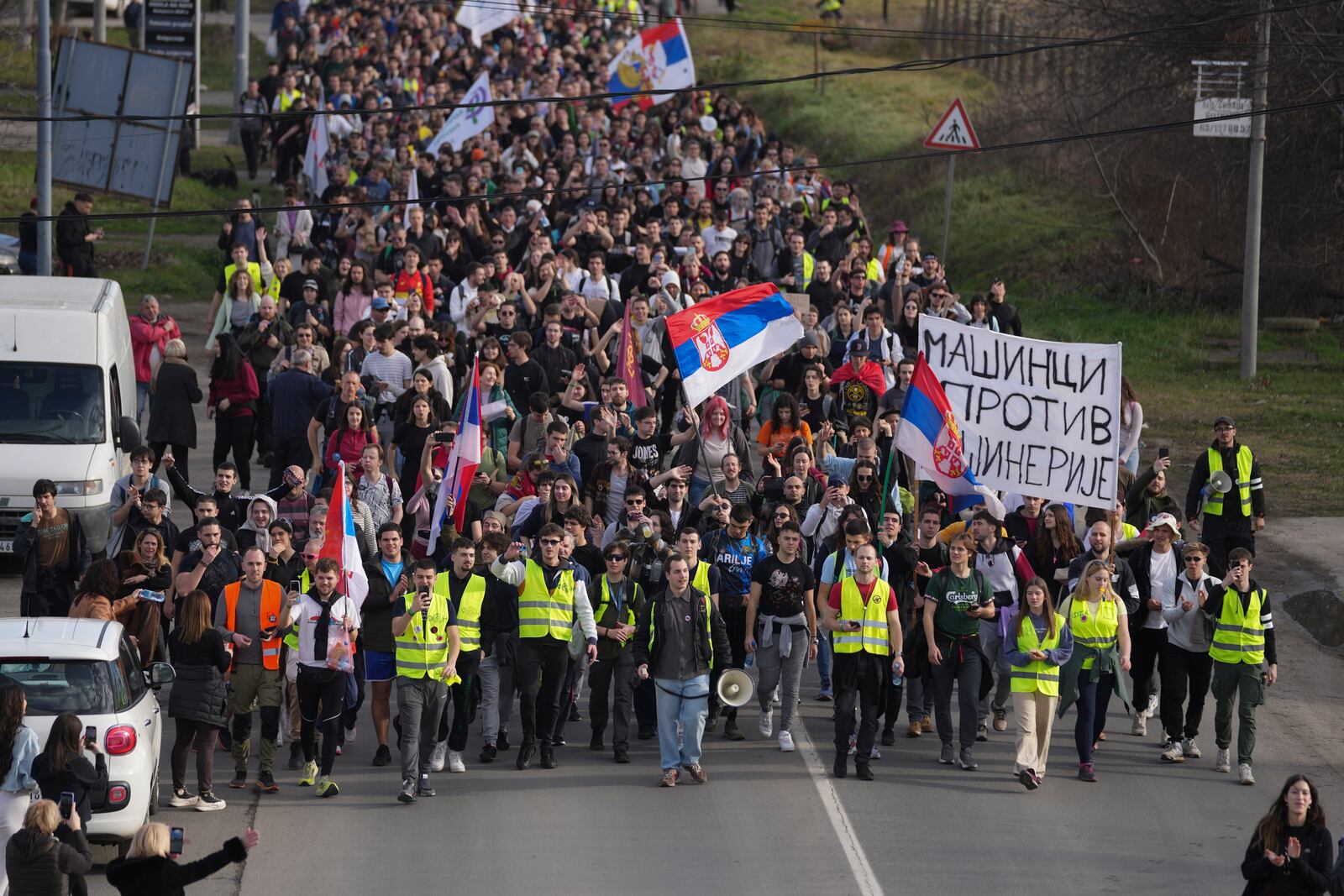 Students walk on the road towards the northern city of Novi Sad, where they will participate in a 24 hour block of three bridges to protest the deaths of 15 people killed in the November collapse of a train station canopy, near the Belgrade suburb of Batajnica, Serbia, Thursday, Jan. 30, 2025. (AP Photo/Darko Vojinovic)