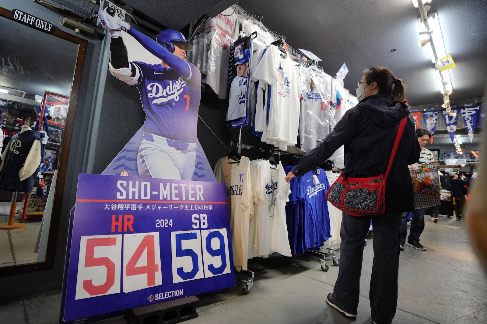 Customers shop around for goods related to Shohei Ohtani of the Los Angeles Dodgers at a sporting goods store, "SELECTION," in Shinjuku district Wednesday, Oct. 23, 2024 in Tokyo. (AP Photo/Eugene Hoshiko)