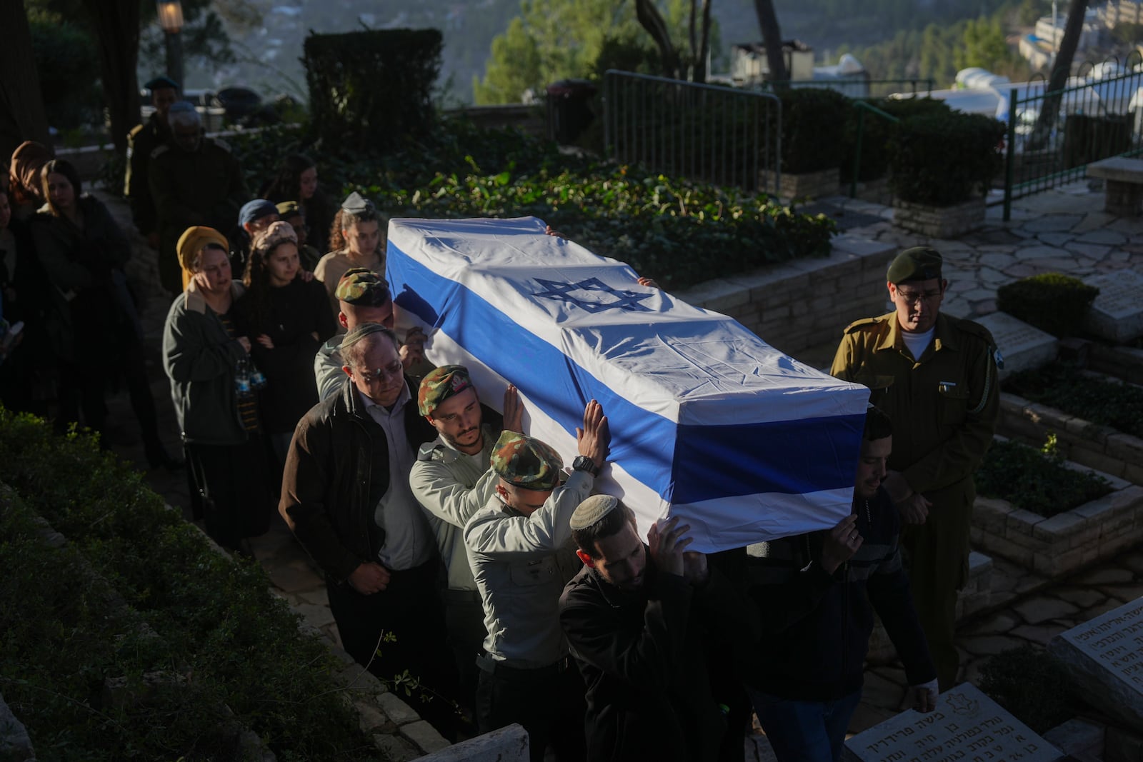 Israeli soldiers and relatives carry the flag-draped casket of 1st Sgt. Hillel Diener, who was killed in combat in the Gaza Strip, during his funeral at the Mount Herzl military cemetery in Jerusalem, Israel, Tuesday, Dec. 24, 2024. (AP Photo/Ohad Zwigenberg)