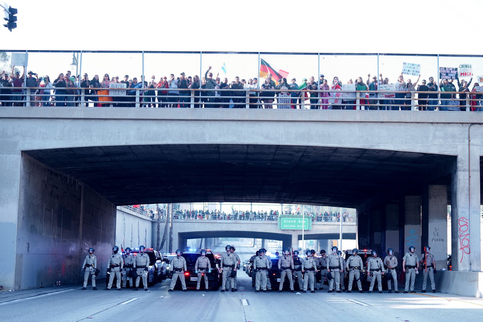 Law enforcement personnel stage in front of a group of demonstrators who shut down the 110 freeway during a protest calling for immigration reform Sunday, Feb. 2, 2025, in Los Angeles. (AP Photo/Eric Thayer)