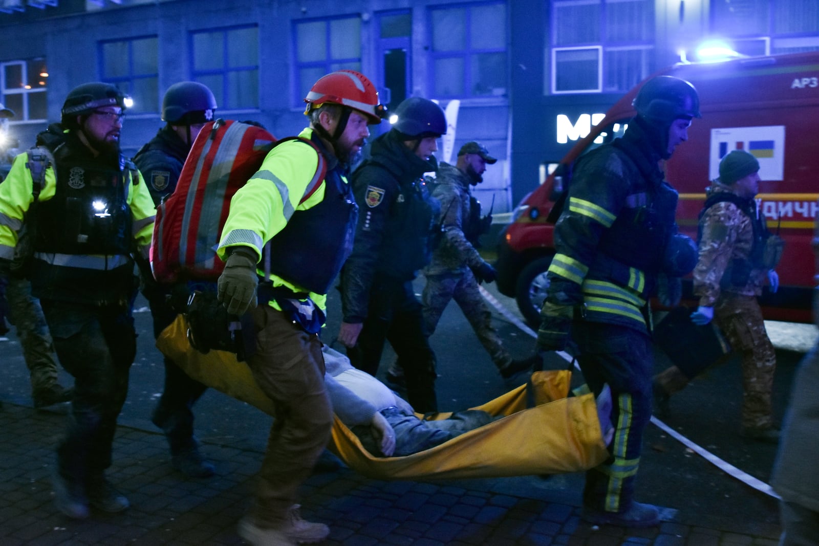 Paramedics carry a body of a civilian killed after a Russian missile hit a private medical clinic in Zaporizhzhia, Ukraine, Tuesday, Dec. 10, 2024. (AP Photo/Andriy Andriyenko)