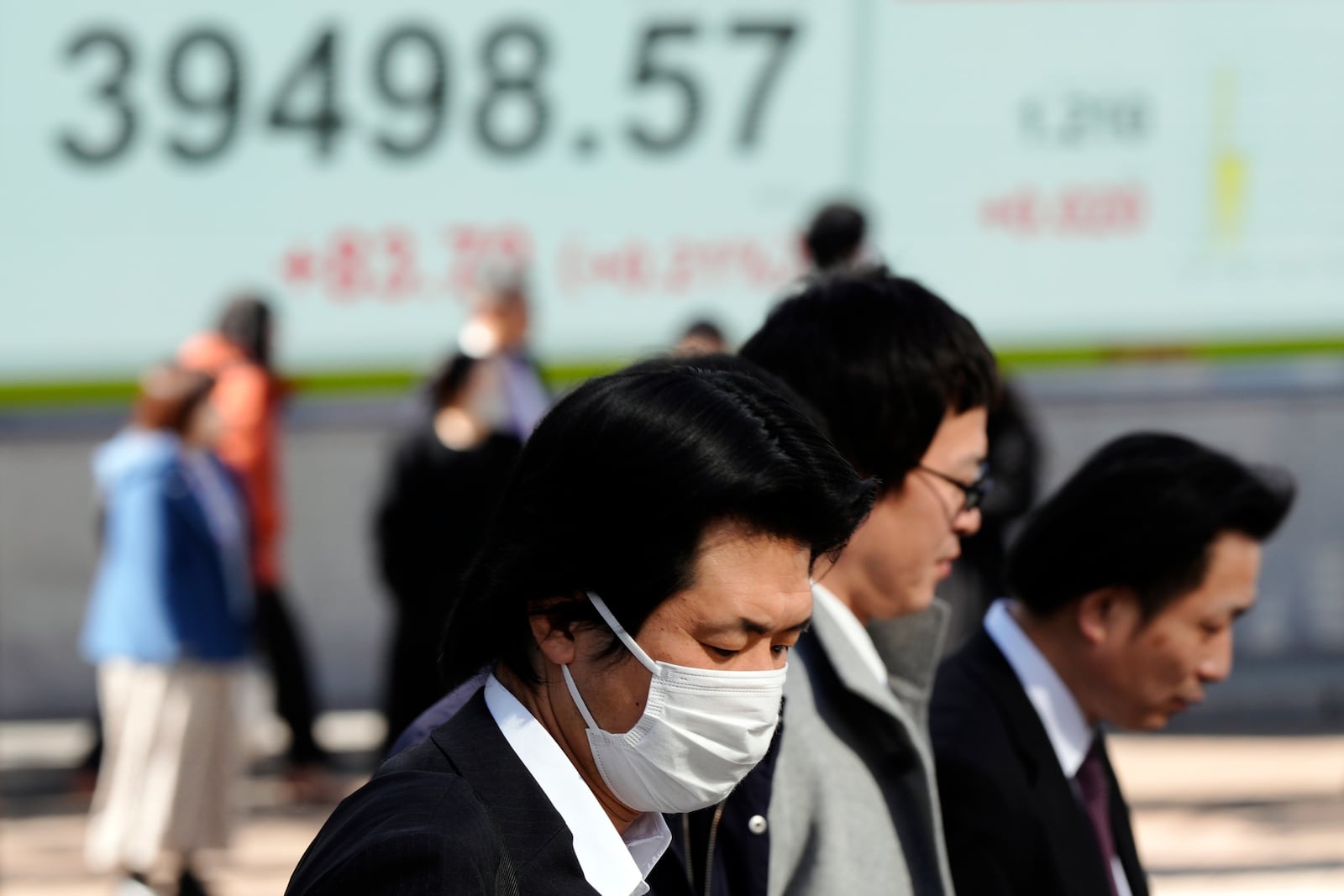 People walk in front of an electronic stock board showing Japan's Nikkei index at a securities firm Thursday, Jan. 30, 2025, in Tokyo. (AP Photo/Eugene Hoshiko)