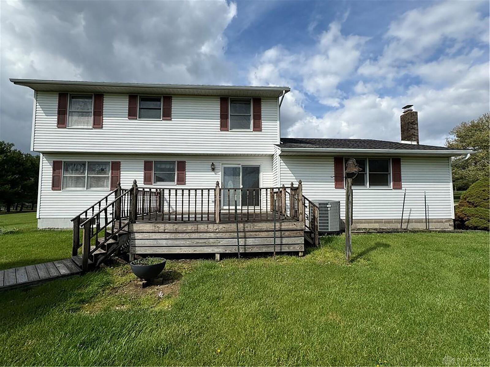 The rear of the home has a wood deck with railings and an attached gazebo. It is also partially fenced.