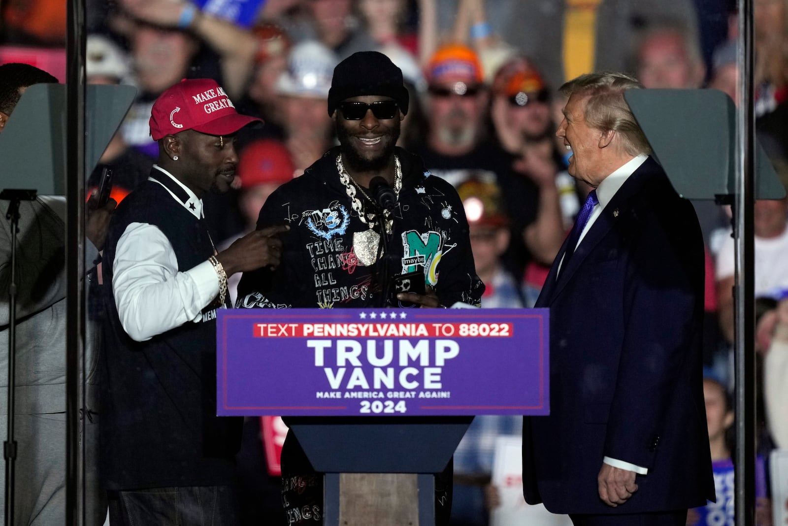 Republican presidential nominee former President Donald Trump listens to former Pittsburgh Steelers Antonio Brown, left, and, Le'Veon Bell, at a campaign rally, Saturday, Oct. 19, 2024, at Arnold Palmer Regional Airport in Latrobe, Pa. (AP Photo/Matt Rourke)