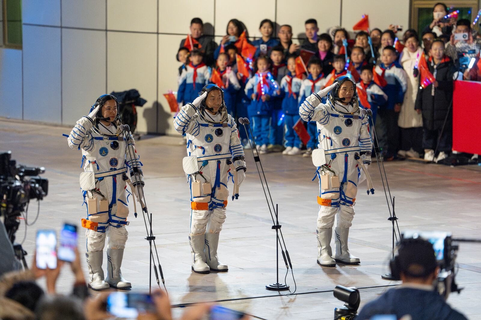 Chinese astronauts Wang Haoze, from left, Cai Xuzhe and Song Lingdong salute as they attend the see-off ceremony for the Shenzhou-19 mission at the Jiuquan Satellite Launch Center in northwestern China, in the early hours of Wednesday, Oct. 30, 2024. (AP Photo/Ng Han Guan)