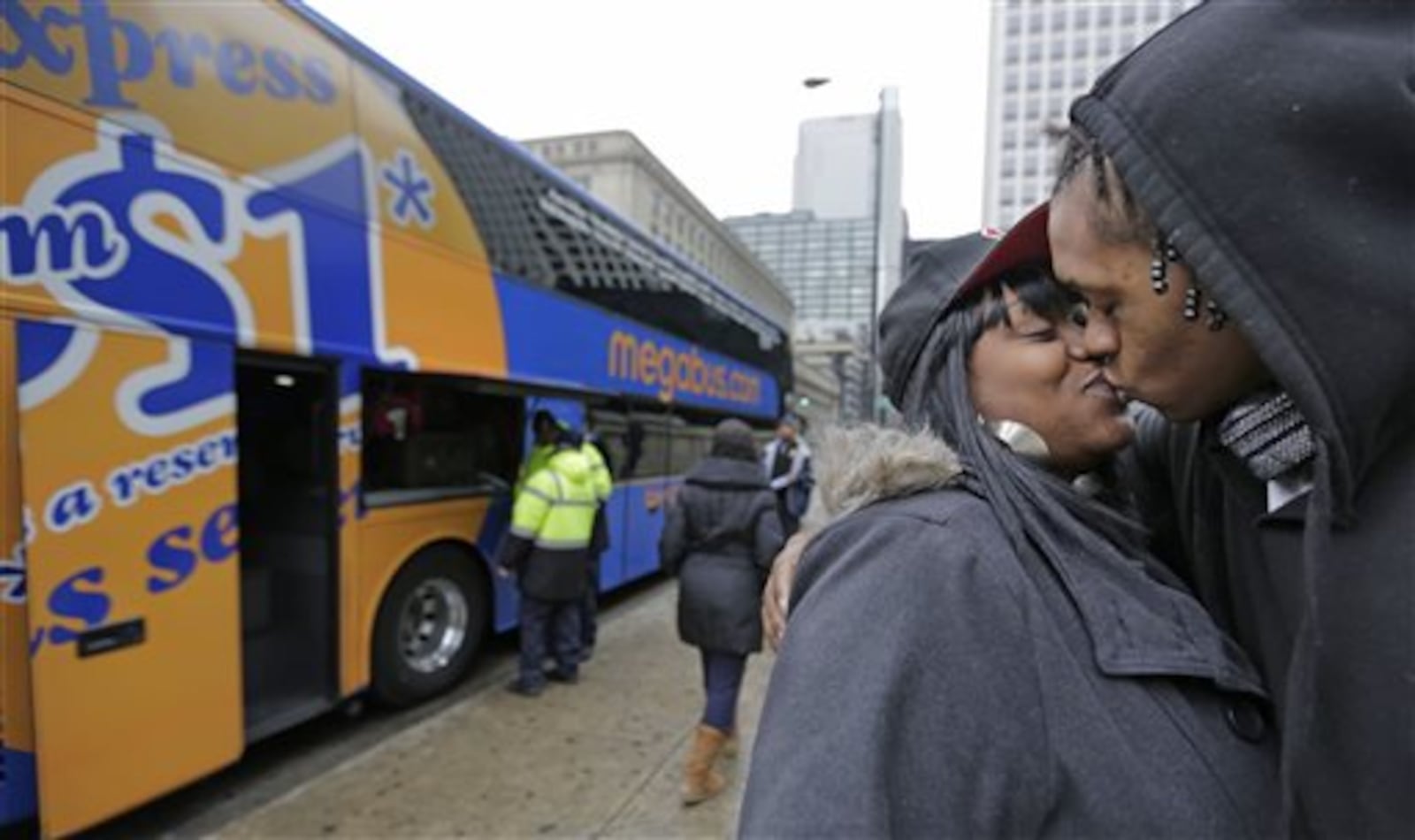 Shay Owens kisses her boyfriend Bryan Jordan before boarding a Megabus for a trip to Atlanta, Tuesday, Nov. 26, 2013, in Chicago. (AP Photo/M. Spencer Green)