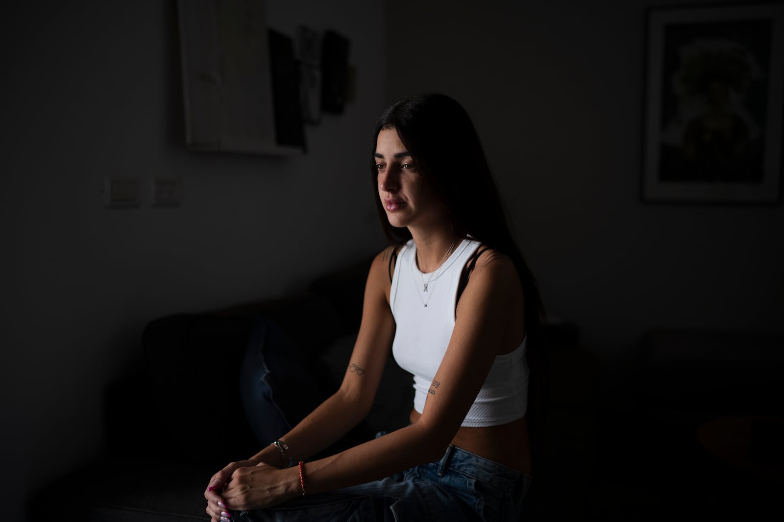 FILE - Ziv Abud talks about the Hamas attack on Oct. 7, 2023, at the Nova music festival during an interview at her house in Tel Aviv, Israel, Sept. 19, 2024. Abud survived, protected by the crush of bodies above her, in a roadside bomb shelter near the Kibbutz Reim. Her boyfriend, Eliya Cohen, was taken captive. (AP Photo/Leo Correa, File)