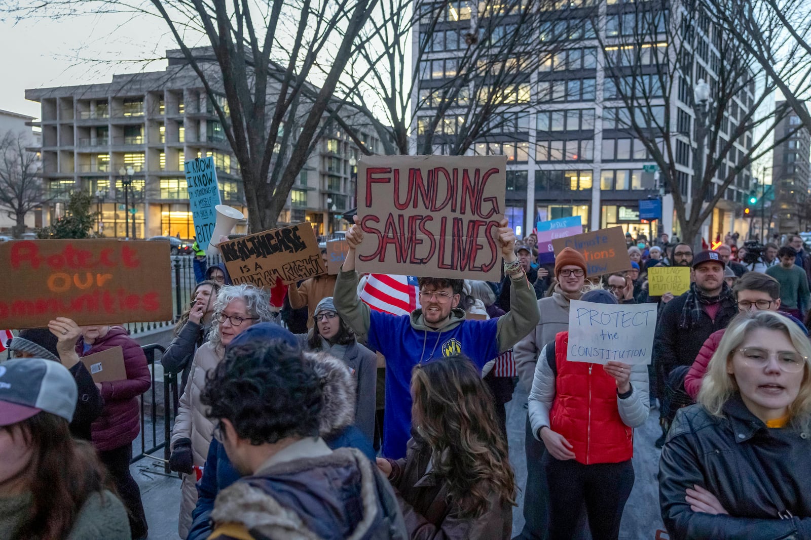 People protest against a funding freeze of federal grants and loans following a push from President Donald Trump to pause federal funding near to the White House in Washington, Tuesday, Jan. 28, 2025. (AP Photo/Ben Curtis)