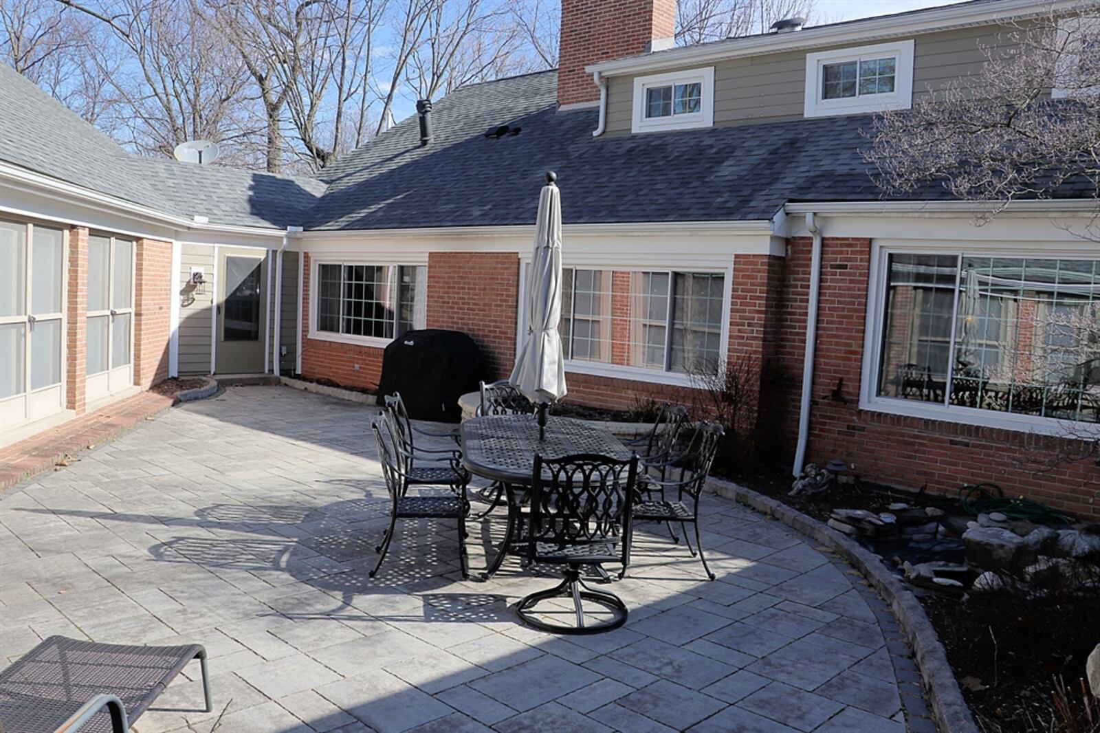 An enclosed breezeway with wet bar leads from the kitchen out to the courtyard patio and to the indoor swimming pool house. 