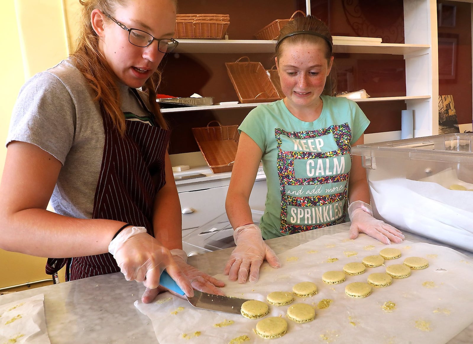 Abigail Lynn and Ella Freeman help get the Le Torte Dolci bakery ready Wednesday for it’s grand opening the next day. Bill Lackey/Staff