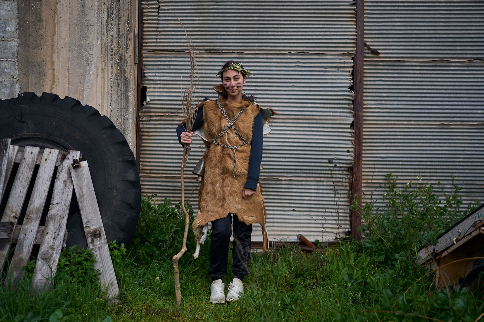 Panagiota Statha, 16, poses for a portrait, dressed in animal skins and heavy bronze bells, as part of carnival celebrations in Distomo, a village in central Greece, on Monday, March 3, 2025. (AP Photo/Petros Giannakouris)